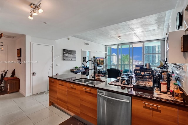 kitchen with light tile patterned flooring, a wall of windows, dishwasher, and sink