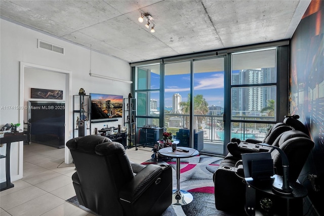 living room with light tile patterned floors and a wall of windows