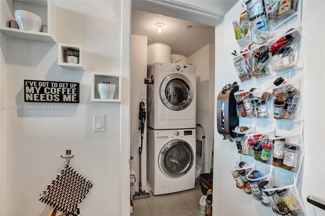 laundry area featuring stacked washing maching and dryer and light tile patterned floors