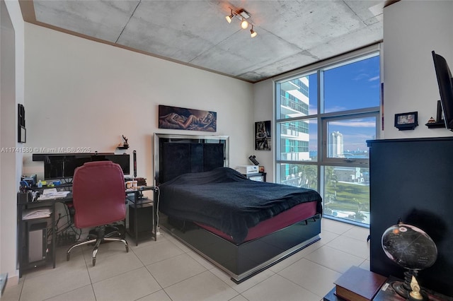 tiled bedroom featuring a wall of windows