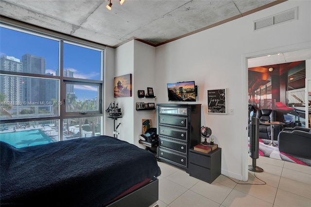 bedroom with light tile patterned floors and floor to ceiling windows