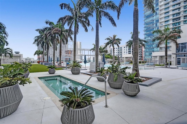 view of swimming pool featuring a hot tub and a patio