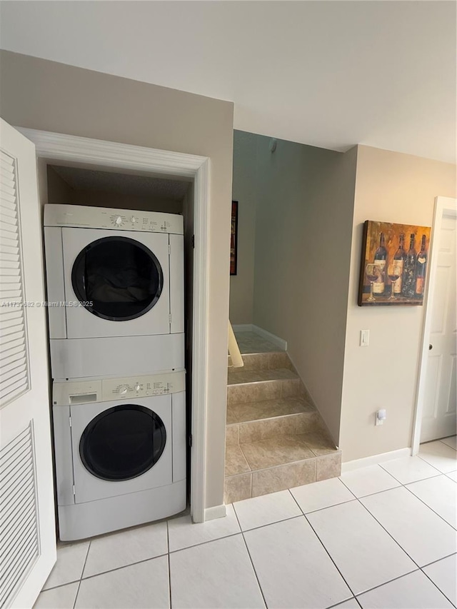 washroom featuring stacked washer and dryer and light tile patterned floors