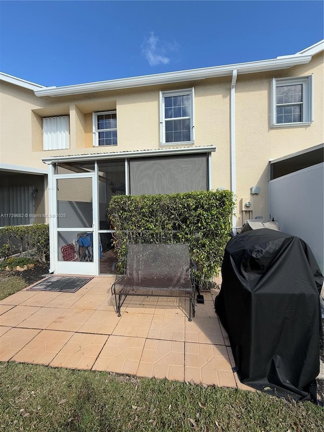 rear view of house with a patio and a sunroom