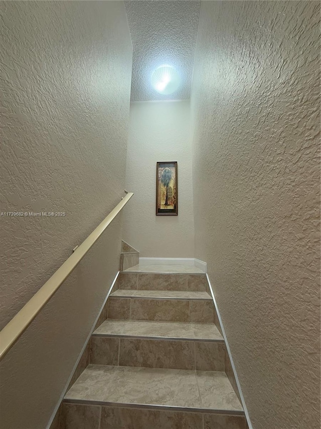 stairs with a textured ceiling