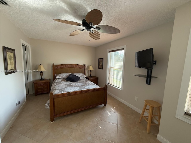 bedroom featuring light tile patterned floors, a textured ceiling, and ceiling fan