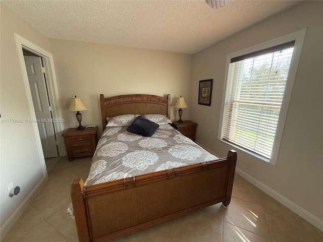 tiled bedroom featuring a textured ceiling