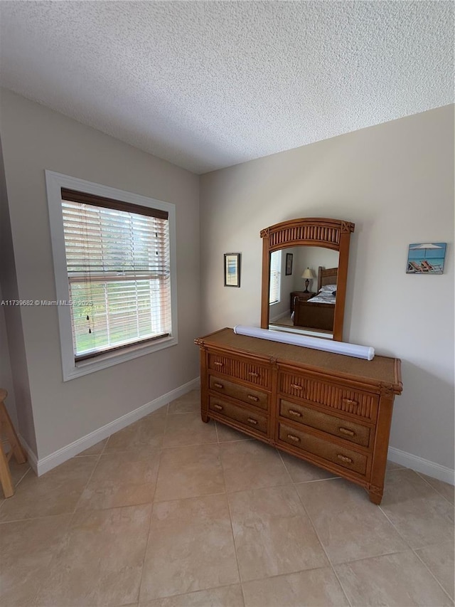 tiled bedroom featuring a textured ceiling