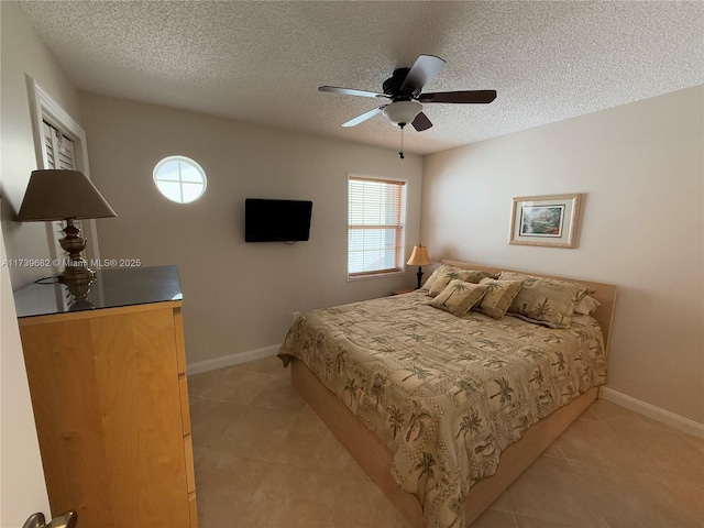 bedroom with light tile patterned floors, a textured ceiling, and ceiling fan