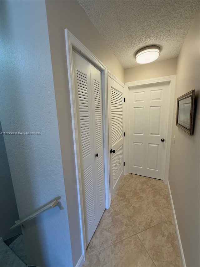 hall featuring a textured ceiling