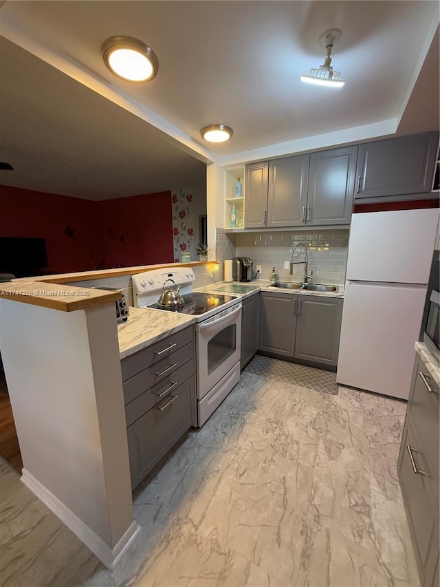 kitchen with gray cabinets, tasteful backsplash, sink, kitchen peninsula, and white appliances