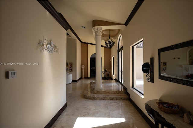 hallway featuring crown molding and an inviting chandelier