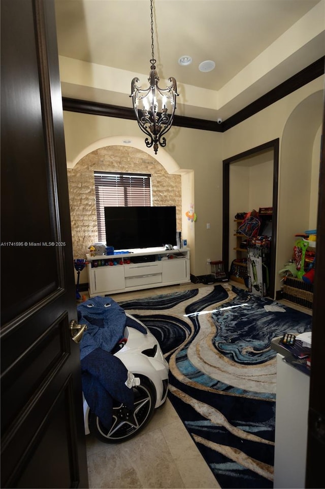 bedroom with an inviting chandelier, a tray ceiling, and crown molding