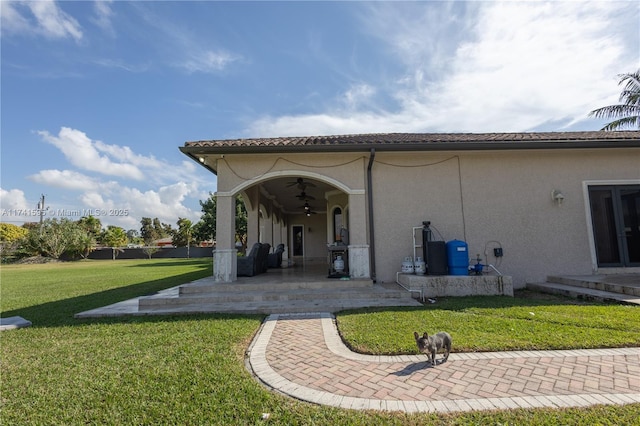 rear view of house with a yard, a patio, and ceiling fan