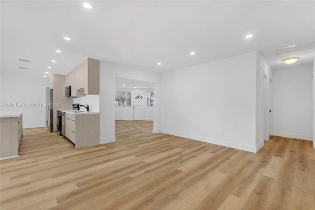 kitchen featuring electric stove, light wood-type flooring, and light brown cabinets