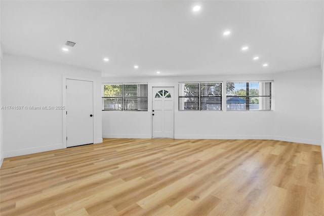 empty room with a healthy amount of sunlight and light wood-type flooring