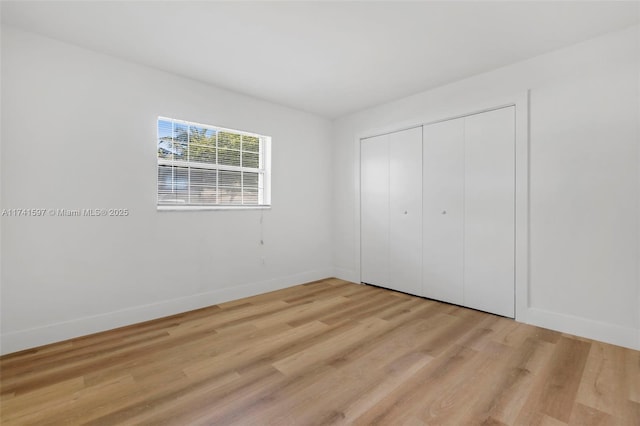 unfurnished bedroom featuring a closet and light wood-type flooring