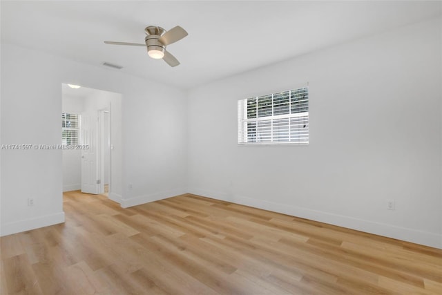 spare room featuring ceiling fan, light hardwood / wood-style flooring, and a healthy amount of sunlight