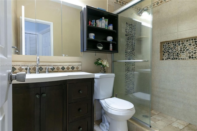 bathroom with tasteful backsplash, tile walls, vanity, an enclosed shower, and toilet