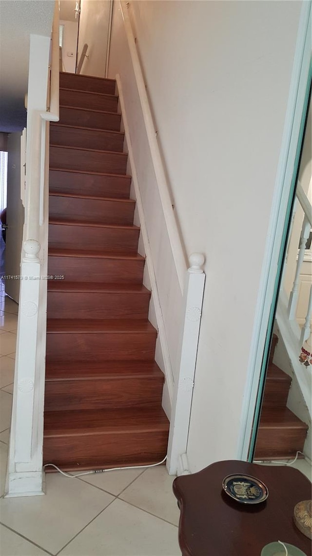 stairs featuring tile patterned flooring