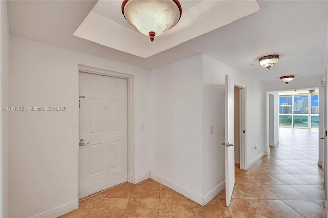 corridor featuring light tile patterned floors and baseboards