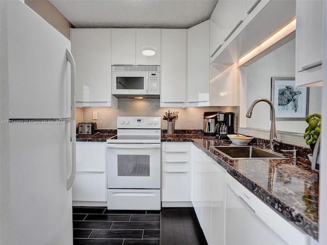 kitchen with backsplash, white appliances, sink, and white cabinets