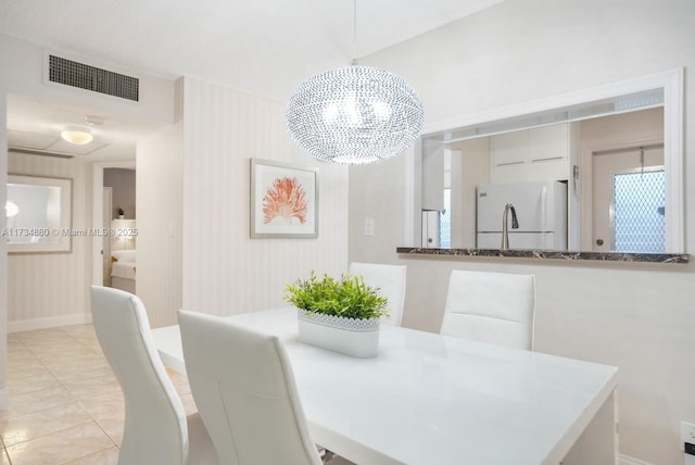 dining space with an inviting chandelier and light tile patterned flooring