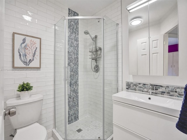 bathroom featuring tile walls, backsplash, vanity, toilet, and walk in shower