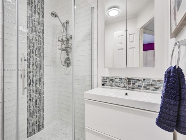 bathroom with tasteful backsplash, vanity, and a shower with shower door