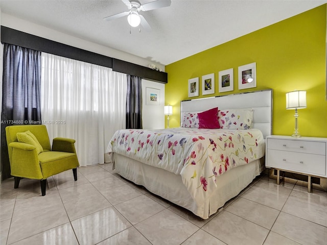 tiled bedroom featuring ceiling fan and a textured ceiling