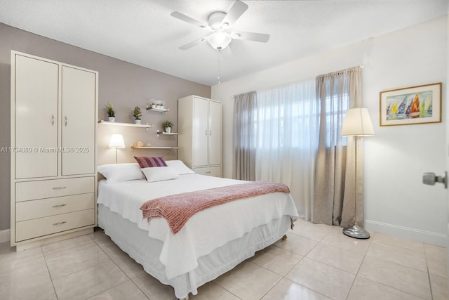 bedroom featuring ceiling fan, a textured ceiling, and light tile patterned floors