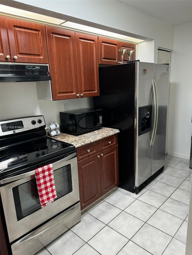 kitchen featuring stainless steel appliances, light stone countertops, and light tile patterned floors