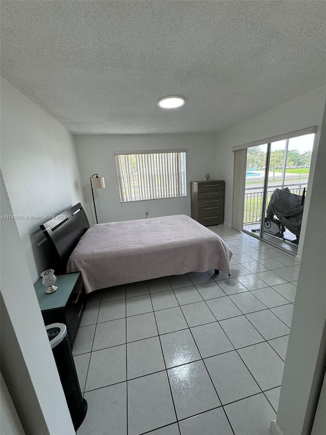 tiled bedroom with access to outside and a textured ceiling