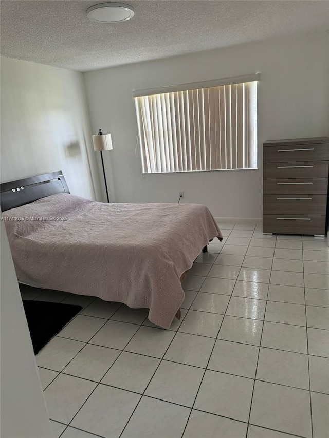 bedroom featuring a textured ceiling and light tile patterned flooring