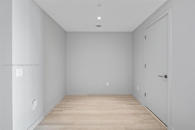 spare room featuring light wood-type flooring, visible vents, baseboards, and recessed lighting