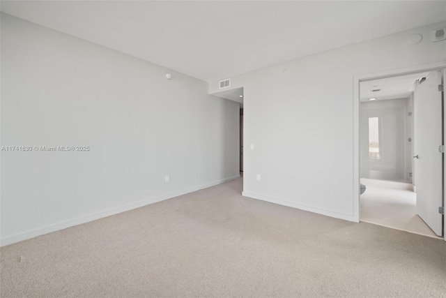 spare room with carpet, visible vents, and baseboards