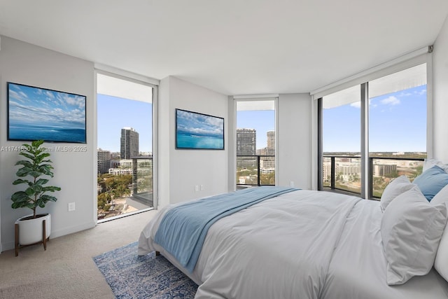 carpeted bedroom with access to exterior, a view of city, baseboards, and expansive windows