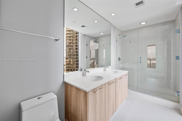 bathroom with toilet, a shower stall, visible vents, and a sink