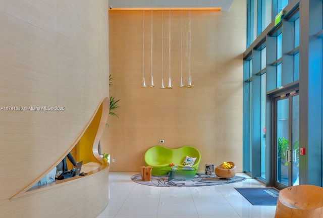 interior space featuring a high ceiling and tile patterned flooring