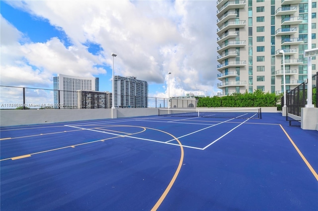 view of sport court featuring a city view, community basketball court, and fence