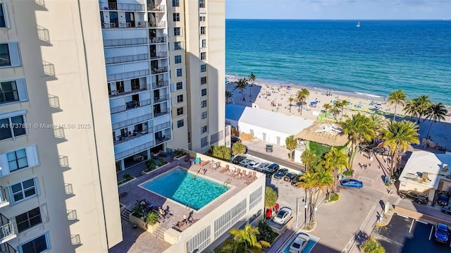 birds eye view of property featuring a beach view and a water view