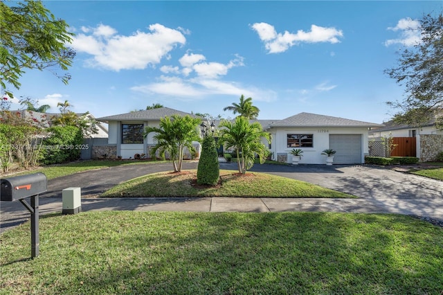 ranch-style home featuring a garage and a front lawn