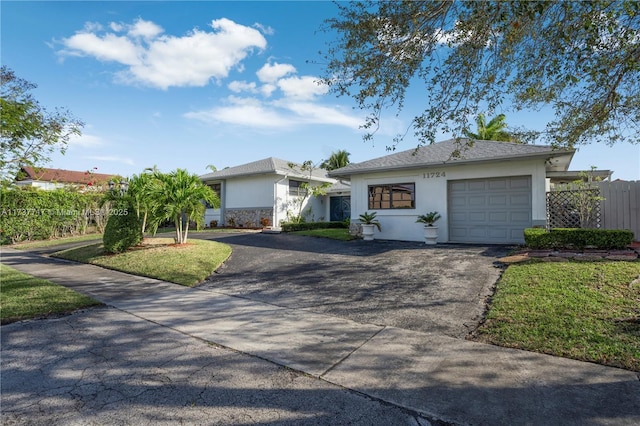 ranch-style house with a garage and a front yard