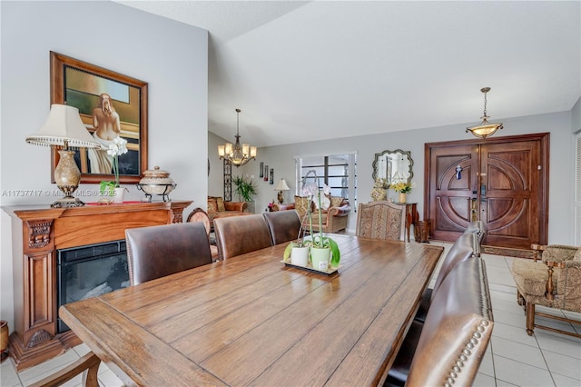 dining room with lofted ceiling, light tile patterned floors, and a chandelier