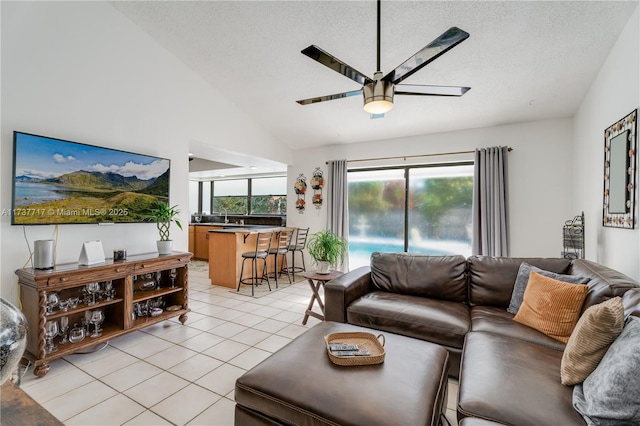 tiled living room with ceiling fan, lofted ceiling, sink, and a textured ceiling