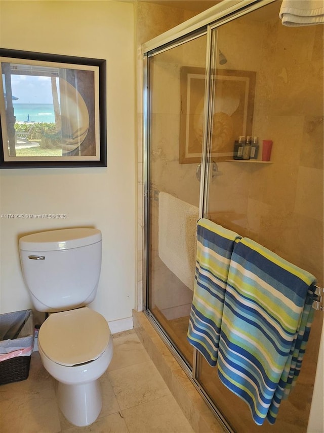 bathroom featuring tile patterned flooring, toilet, and walk in shower