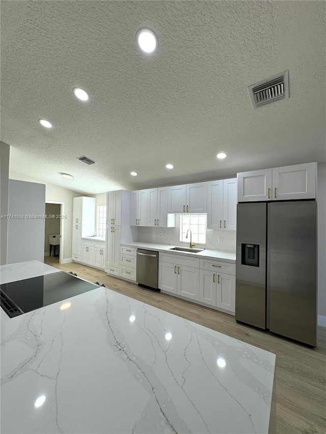 kitchen featuring visible vents, a sink, recessed lighting, stainless steel appliances, and light wood finished floors