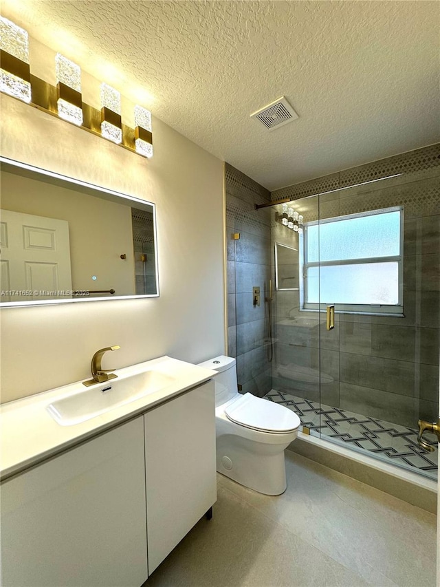 bathroom with vanity, visible vents, a stall shower, a textured ceiling, and toilet