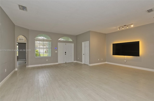 unfurnished living room featuring light wood-type flooring, baseboards, and visible vents