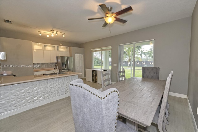 dining area featuring light wood-style floors, baseboards, visible vents, and ceiling fan